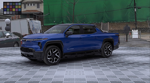 A blue electric pickup truck parked on a white grid-patterned ground outdoors.