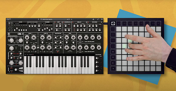 A black analog synthesizer with white keys next to a square grid controller with a hand pressing a button.
