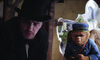 A man in a black top hat leans in to look at a small, furry creature wearing a blue military-style uniform.
