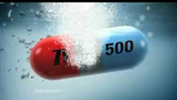 A red and blue medicinal capsule with the number 500 dissolving in bubbling water.