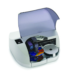 A white laboratory machine with its translucent protective cover raised, revealing colorful internal components.