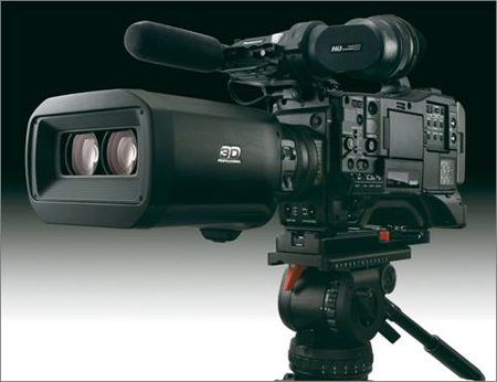 A professional black 3D video camera with dual lenses mounted on a tripod against a dark background.