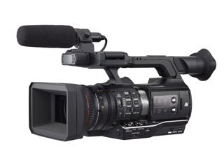 A black professional video camera with a large lens, top handle, and a shotgun microphone attached.