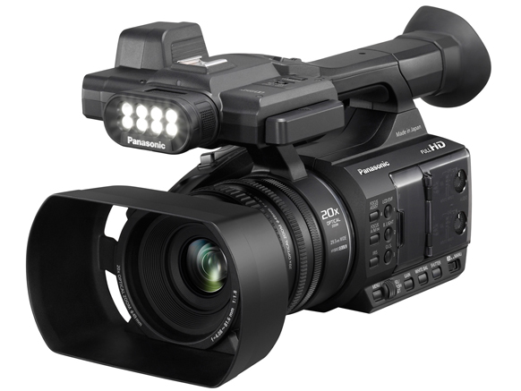 A black Panasonic professional video camera with a large lens hood and an attached LED light unit.