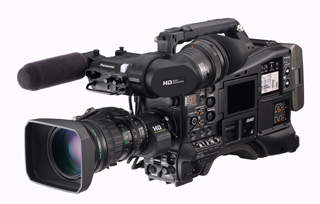 A professional black video camera with a large lens, a microphone, and various control buttons.