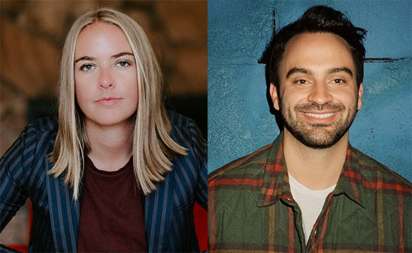 A blonde woman in a striped blazer and a man with dark hair and a beard in a plaid shirt.