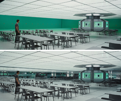A man stands in a large, futuristic cafeteria with white tables, grey chairs, and a central control pod.