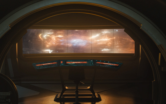 A dark spaceship bridge console overlooks a wide panoramic view of a glowing orange and white nebula.