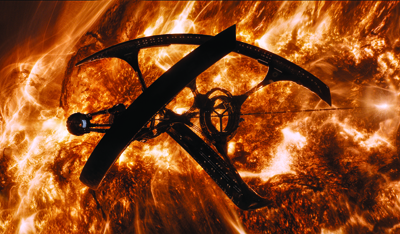A dark, crescent-shaped spacecraft silhouette set against a bright, swirling orange and yellow solar surface.