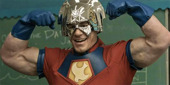 A muscular man in a red and blue superhero costume with a silver helmet flexing his biceps.