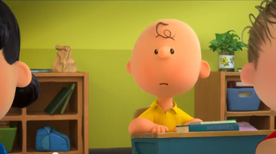A 3D animated bald boy in a yellow shirt sits at a school desk looking sad.