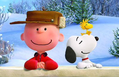 Charlie Brown wearing a brown hat and red jacket sits next to Snoopy in a snowy winter setting.