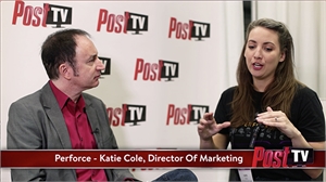 A man in a grey blazer and a woman in a black t-shirt talk during an interview.