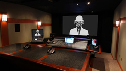 A dark control room with a large screen displaying a graphic of a man in a bowler hat.
