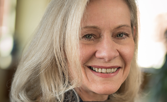 A smiling woman with long blonde hair looking toward the camera.