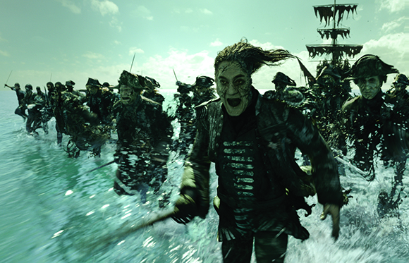 Undead sailors with tattered clothing charge through splashing ocean waves toward the viewer.