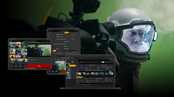 A person wearing a tactical helmet with a visor next to multiple digital interface displays.