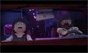 Two wide-eyed, shocked animated characters sit inside a dimly lit vehicle at night.