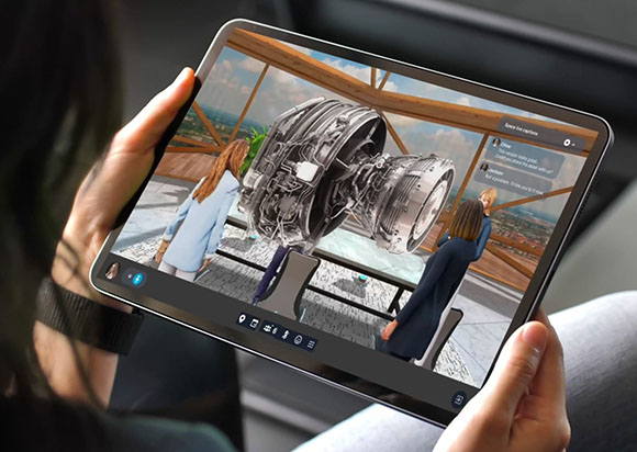 Hands holding a tablet showing a 3D jet engine model and digital avatars in an augmented reality workspace.