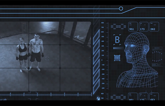 Digital interface showing a surveillance view of two people in a gym and a blue wireframe human head profile.