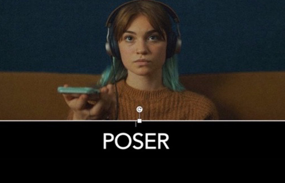 A woman with headphones and blue-tinted hair holds a small device against a dark background.