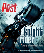 A dark, futuristic motorcycle with a rider in a black suit speeds forward, leaving sparks in its wake.
