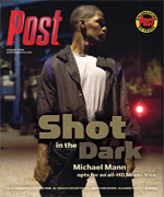 Man in dark jacket and white t-shirt stands looking right. Text reads "Shot in the Dark" and "Michael Mann opts for an all-HD