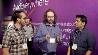 Three men in casual button-down shirts converse in front of a purple Avid Everywhere banner.