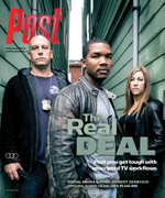 Three people stand in an alleyway. The central figure is a Black man. A White man and a White woman stand to his left and rig