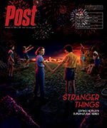 The cast of Stranger Things stands in a field at night, holding hands, with fireworks exploding overhead.