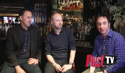 Three men sitting at a bar counter with various liquor bottles on shelves in the background.