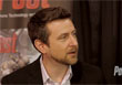 A man with dark hair and a goatee wearing a dark blazer and light collared shirt.