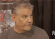A man with graying hair and a mustache looking toward the right.