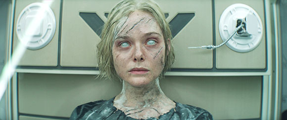 A woman with short blonde hair, scarred skin, and milky white eyes stares directly ahead.