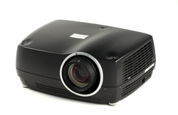 A black digital projector with a large lens and ventilation grilles on a white background.