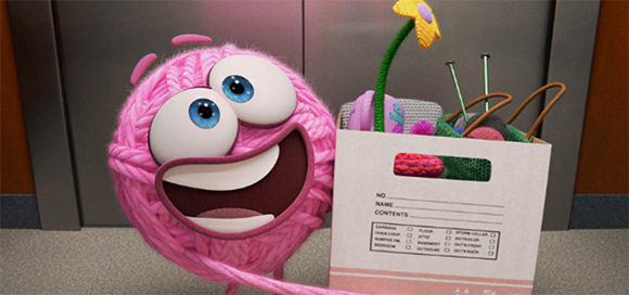 A round, pink yarn monster with large blue eyes smiles next to a white bag filled with knitting supplies.