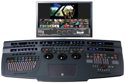 A professional video editing workstation with a large control surface and a monitor showing video footage.