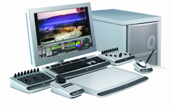 A computer monitor displaying video editing software, a keyboard, various control consoles, and a computer tower.
