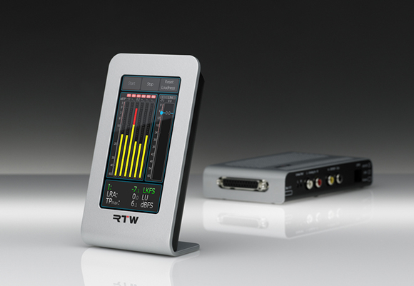 A silver RTW audio loudness meter displaying yellow level bars and a separate silver hardware interface unit.