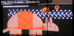 A colorful projection of a large, stylized animal with orange stripes against a dark background with white patterns.