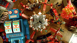 A large blue toy robot stands in a crowded toy store viewed from above.
