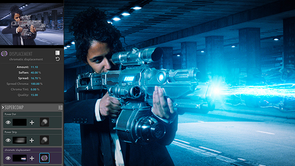 A person in a suit aims a glowing blue sci-fi weapon in a dark, blue-lit parking garage.