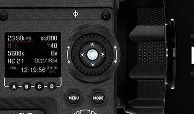 Close-up of a camera's digital display showing frame rate, ISO, and color temperature settings.