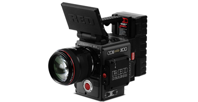 A black RED Dragon digital cinema camera with a large lens and an upward-tilted monitor.