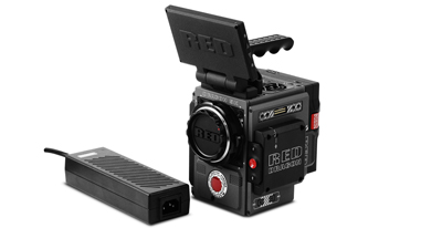 A black RED Digital Cinema camera with an open top screen and a separate rectangular battery pack.
