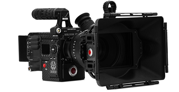 A black RED digital cinema camera equipped with a large lens, matte box, and top handle against a white background.