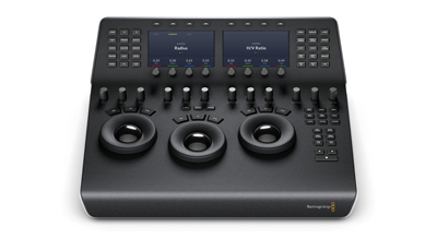 A black professional video editing control panel with three large trackballs and two digital screens.
