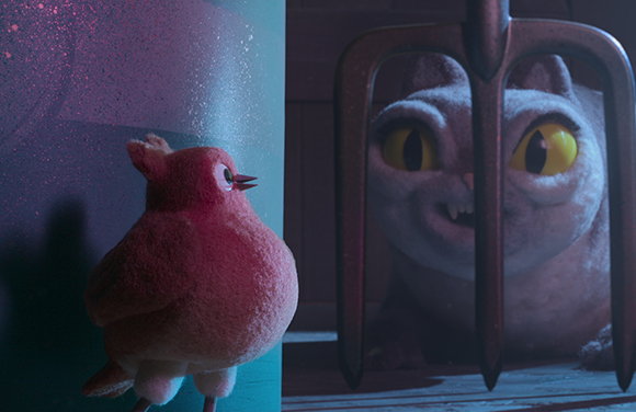 A small pink bird stares up at a large, wide-eyed white cat through the metal tines of a pitchfork.