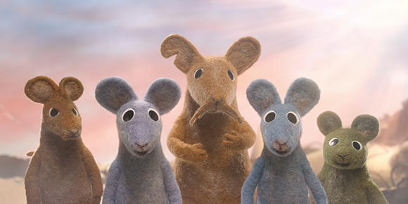 Five anthropomorphic felt mice of various colors standing against a soft, sunset-colored sky.