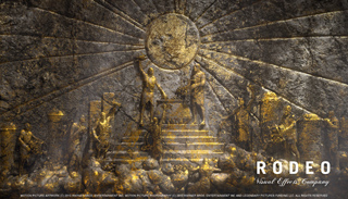 A textured, golden relief sculpture featuring various human figures arranged beneath a large, radiating sun.